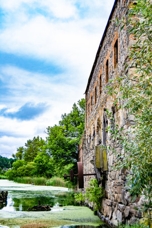 Photography on theme outstanding building beautiful brick old water mill, photo consisting of big brick old water mill outdoor in rural, brick old water mill situated on riverside country lifestyleの写真素材