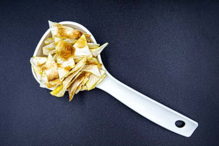 Many delicious potato chips on grocery market counter, tasty food consisting of fresh raw potato chips close up, beautiful texture ripe of natural potato chips on backgroundの写真素材