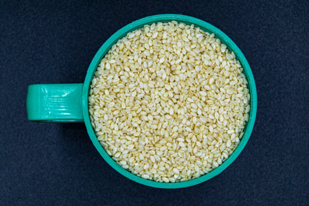 Many delicious summer sesame seeds on grocery market counter, tasty organic food consisting of fresh raw sesame seeds close up, beautiful texture ripe of natural sesame seeds on background