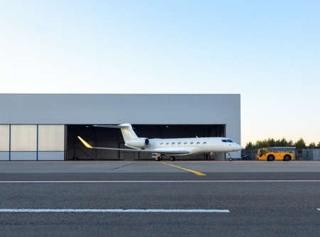 Luxury business jet is being towed out of the hangarの写真素材