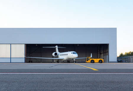Luxury business jet is being towed out of the hangarの写真素材