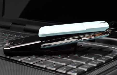 Two Cellular phones on a laptopの写真素材