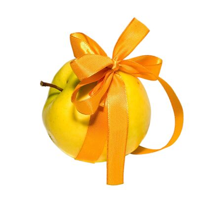 yellow apple with a gift bow on a white backgroundの写真素材