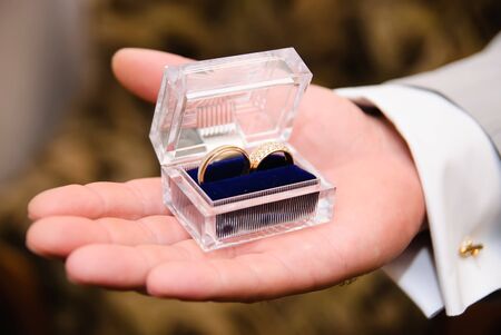 man's hand holding a transparent box with a wedding bandsの写真素材