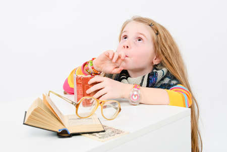 studio shot of pretty little girl reading a bookの写真素材