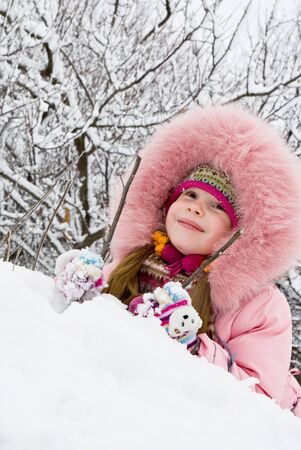 little girl in a winter clothing in a winter woodsの写真素材