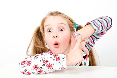 studio shot of pretty little girl pointing at her watchの写真素材