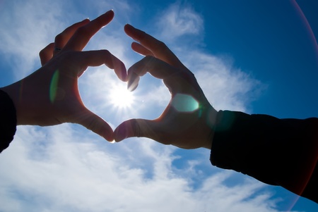 two hands looks like heart with sun insideの写真素材