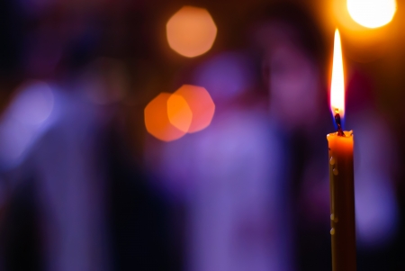 Burning candle on a blurred color backgroundの写真素材