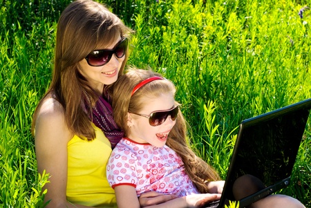 Smiling young mother with little daughter. Sunny summer day.の写真素材