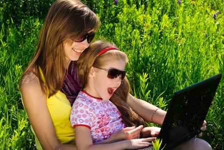 Smiling young mother with little daughter. Sunny summer day.の写真素材