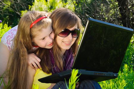 Smiling young mother with little daughter. Sunny summer day.の写真素材