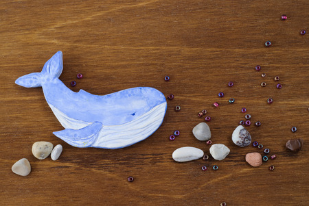 Whale made of clay on a wooden background, Handmade arts and crafts project.の写真素材