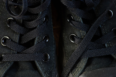 Old dirty black sneakers. Close up view. Low key shot.の写真素材