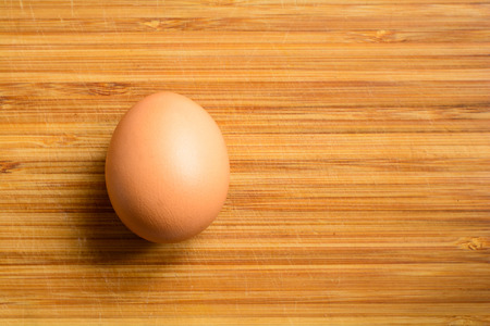 Fresh natural raw chicken egg on a wooden background. Close up top view.の写真素材