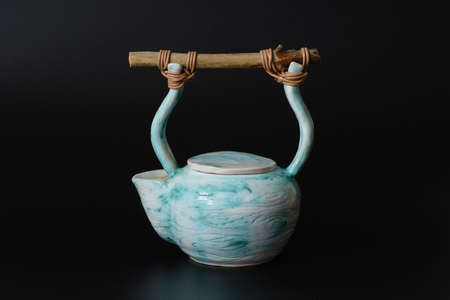 Photography of the authentic handmade ceramic craft ware on a black background. Teapot.の写真素材