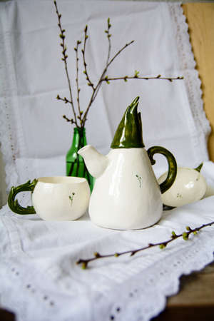 Photography of the authentic handmade ceramic craft ware in a cozy home interior. Teapot and cup.の写真素材