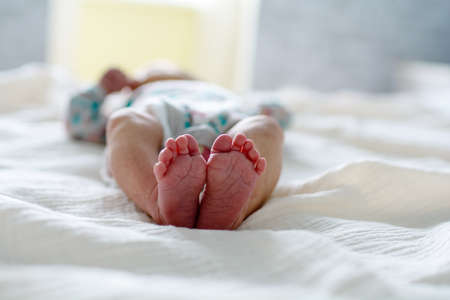 Cute newborn baby feet with little toes in a selective focusの写真素材