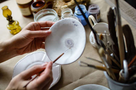 The process of hand painting a ceramic hand made dishes. Selective focus.の写真素材