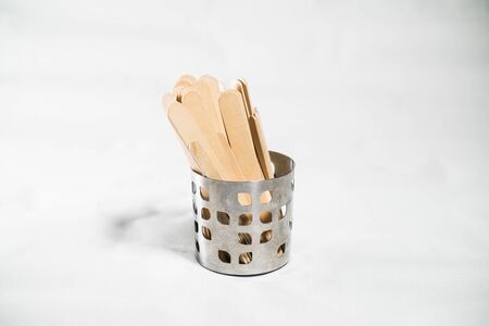 Wooden spatulas in a metal can on a whiteの写真素材