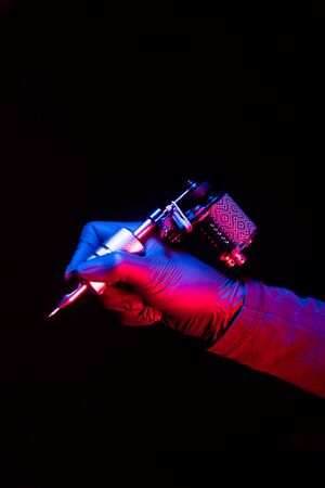men hands hold a stylish tattoo machineの写真素材