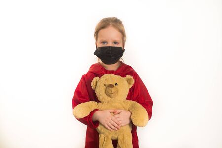 girl in a protective mask holds a toyの写真素材