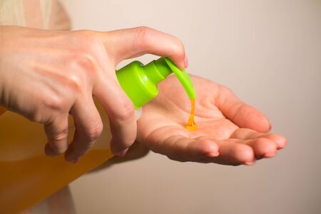 close-up girl squeezes soap and washes handsの写真素材