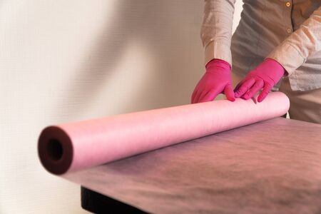 lays a disposable sheet on a massage couchの写真素材