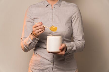 in female hands wooden spatula with sugar pasteの写真素材