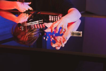 angry clumsy hand of a young girl reaches for drugs lying on the table. addiction concept.