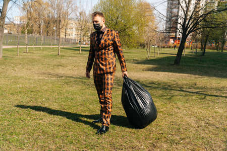 The general plan of a young European who takes out garbage in huge packages. environmental concept.の写真素材