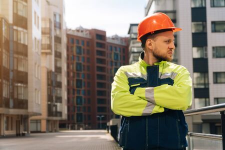 Closeup of a builder engineer holding a helmet with his hand. A man wants to take off his special helmet.の写真素材