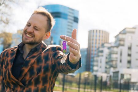 A joyful young man shows the keys to the apartment. concept of buying real estate.