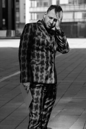 Caucasian young businessman in shock holds his hands on his head. The concept of failure to work in...