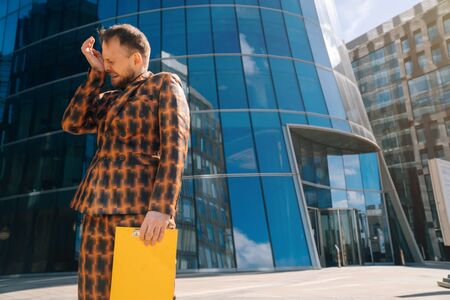 Caucasian young businessman in shock holds his hands on his head. The concept of failure to work in the futureの写真素材