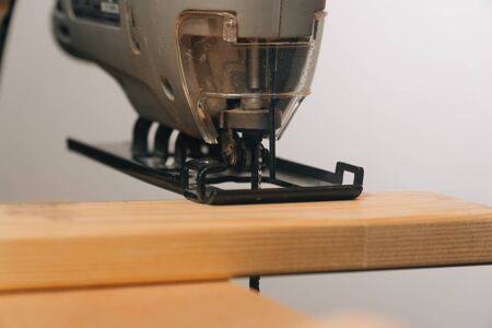 A man uses a tool to saw a tree. The concept of carpentry. Worker in a woodworking workshop.の写真素材