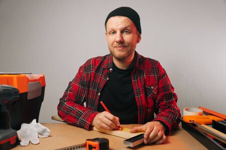 Portrait of a Caucasian brutal man with a beard, who is engaged in carpentry. The concept of a carpenter in the worksの写真素材
