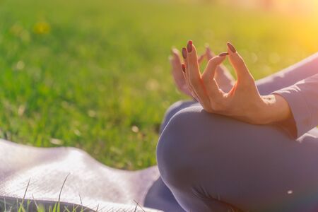 Hands closeup namaste. young Caucasian girl practices yoga meditation in the fresh air. The concept of peace of mind. Balance and harmony in lifeの写真素材