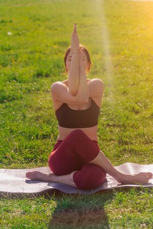 Vertical frame of a young athletic attractive woman practicing yoga, performing Garudasan exercises in her arms, eagle pose, training, wearing sportswear,の写真素材