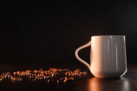A white beautiful cup of tea or freshly brewed coffee is standing on a beautiful rag against a dark background. copy space next to the mugの写真素材