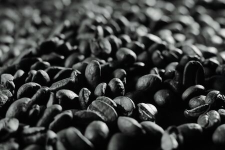 roasted coffee beans, can be used as background. Coffee production concept for coffee shop. Grains after roasting on a black and white backgroundの写真素材