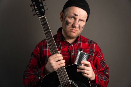 vertical portrait of a young street musician who is upset. earning concept on the city streets.の写真素材