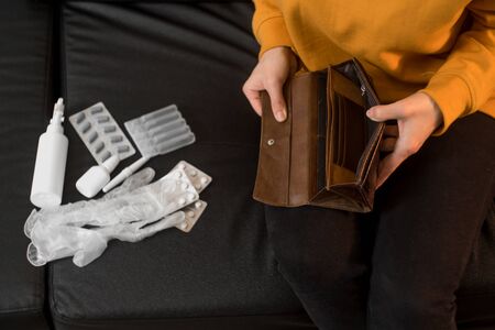 Close up of female hands holding an empty wallet. The concept of money spent on drugs to treat the...