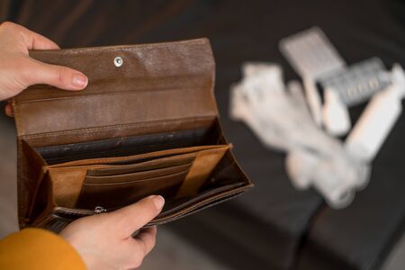 Close up of female hands holding an empty wallet. The concept of money spent on drugs to treat the...