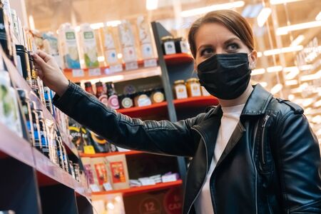 Portrait of a young caucasian girl choosing sporting goods in a fitness store. The concept of a healthy lifestyle and proper nutritionの写真素材