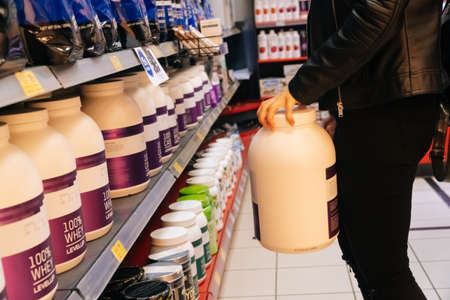 SAINT PETERSBURG, RUSSIA - APRIL 28, 2020 Close up of female hands holding sports supplements in a fitness store. The concept of a healthy lifestyle and proper nutritionのeditorial素材