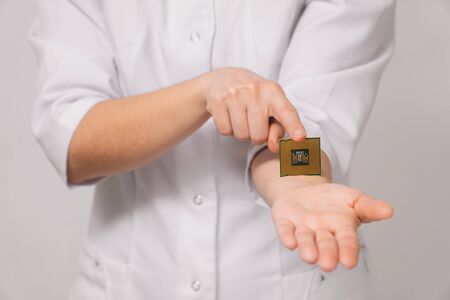 Close-up female doctor shows on her hand how to insert a microchip identification of people's data....