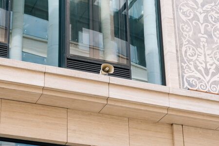 loudspeaker on the wall of the office building. Business Center alerts city dwellers and businessmen using loudspeakers.の写真素材