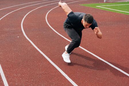 The runner prepared to run. The sprinter sits at the start on a treadmill at the stadium. The...
