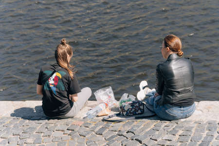 People are sitting on the promenade. social distance, walk in the fresh air on a summer day.のeditorial素材